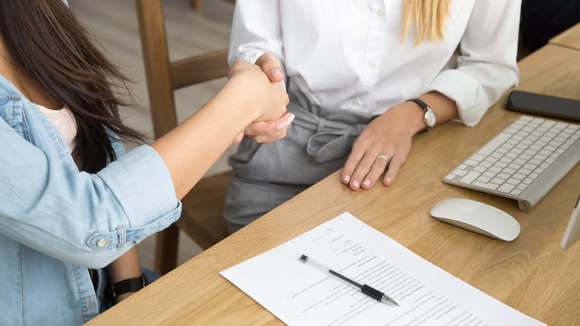 Two women partners handshaking after signing business contract at meeting, female client or customer and manager agent broker closing good deal, female hands shaking making agreement, close up view